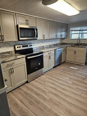 a kitchen with a sink stove and microwave