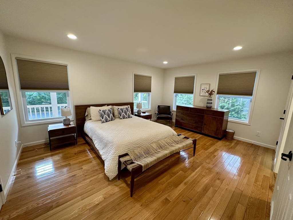 151 Tashmoo Avenue Tisbury, MA 02568 - Photo 13 of 28 a spacious bedroom with a bed and wooden floor