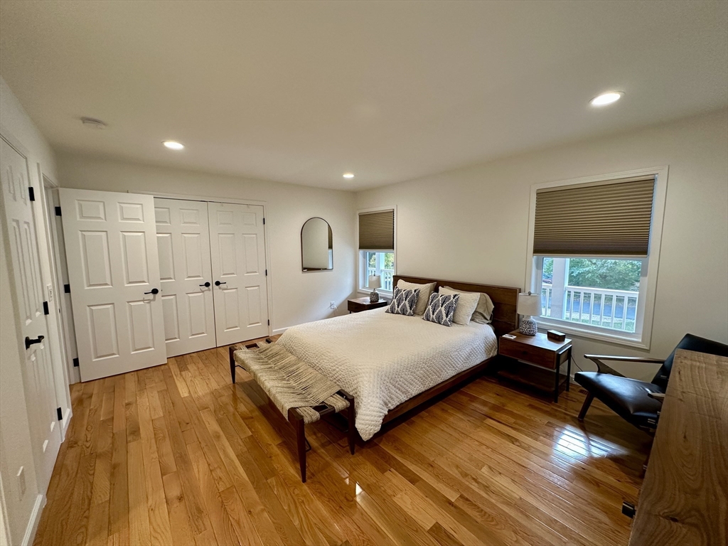 151 Tashmoo Avenue Tisbury, MA 02568 - Photo 14 of 28 a spacious bedroom with a bed and wooden floor