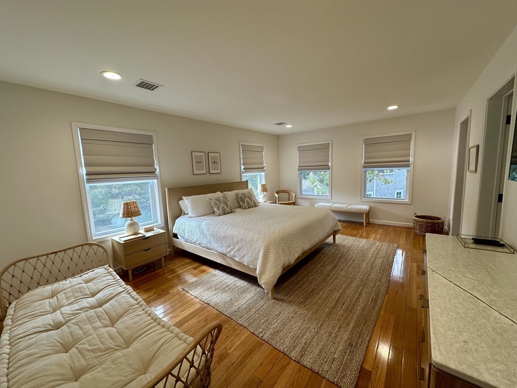 151 Tashmoo Avenue Tisbury, MA 02568 - Photo 18 of 28 a bedroom with a large bed and a chandelier