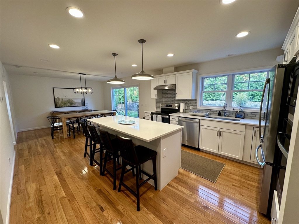 151 Tashmoo Avenue Tisbury, MA 02568 - Photo 6 of 28 a kitchen with a sink a stove a dining table and chairs