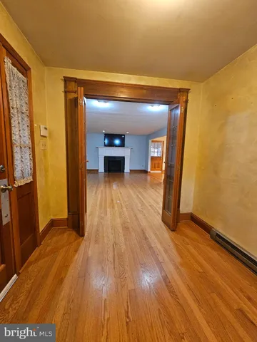 a view of a hallway with wooden floor and staircase