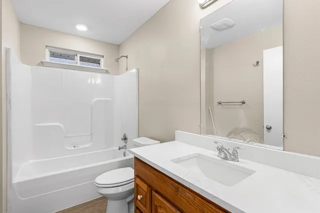a bathroom with a granite countertop sink toilet and shower