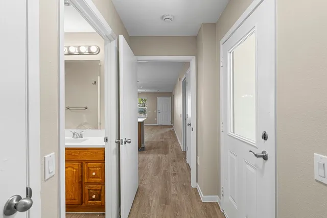 wooden floor with a view of bathroom
