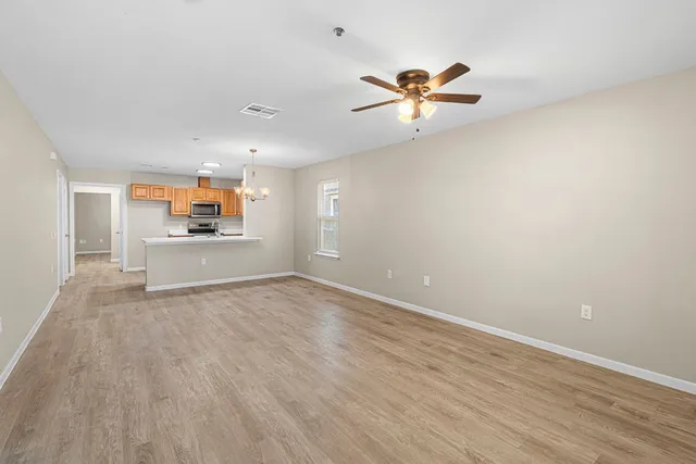 a view of a livingroom with a ceiling fan and wooden floor