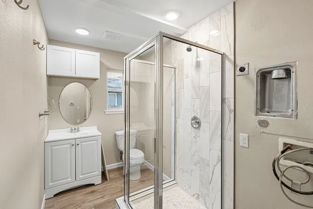 a bathroom with a sink a toilet and shower