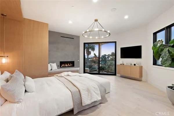 a bedroom with a large bed and a chandelier