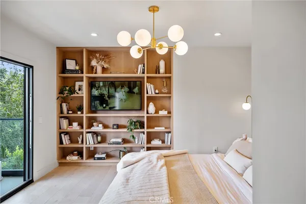 a bedroom with a large bed and large windows