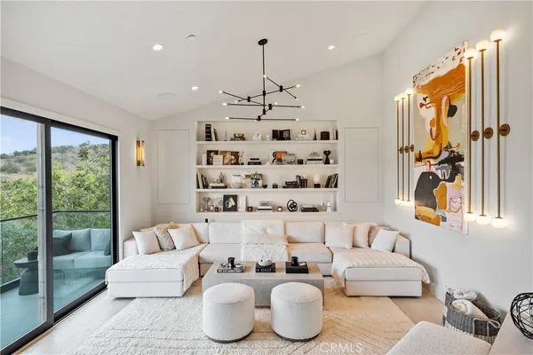a living room with furniture kitchen view and large window
