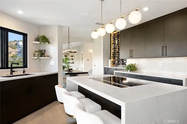 a kitchen with stainless steel appliances a stove a sink a oven a dining table and chairs