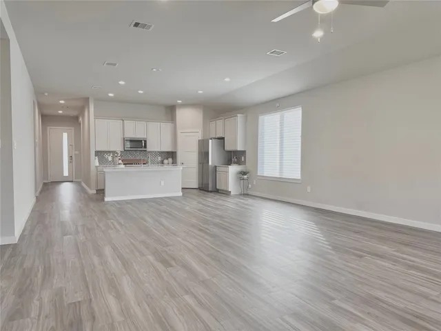 a view of a kitchen with wooden floor and a window