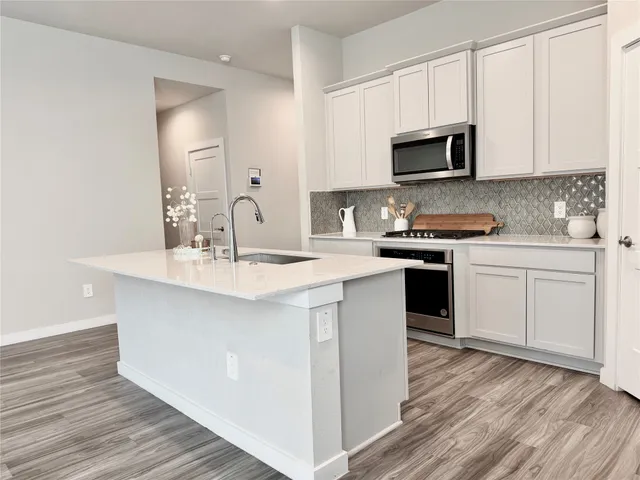 a kitchen with stainless steel appliances granite countertop a sink stove and microwave