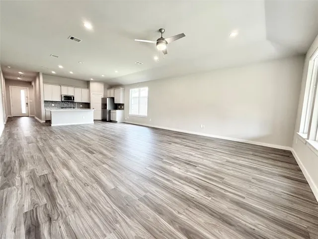 a view of a livingroom with kitchen and stainless steel appliances