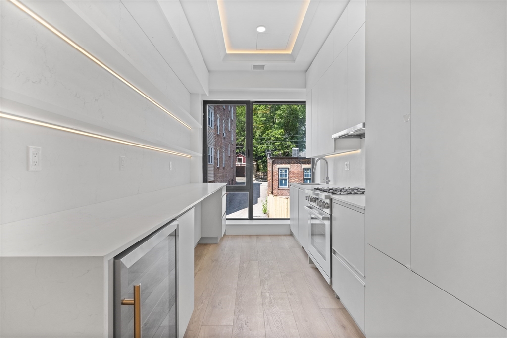 1578 Beacon Street, Unit PH2 Brookline, MA 02446 - Photo 2 of 18 a kitchen with white cabinets and white appliances