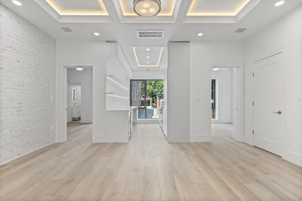 a view of a hallway with wooden floor and entryway