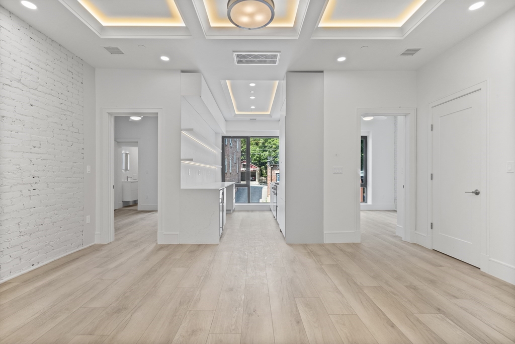 1578 Beacon Street, Unit PH2 Brookline, MA 02446 - Photo 3 of 18 a view of a hallway with wooden floor and entryway