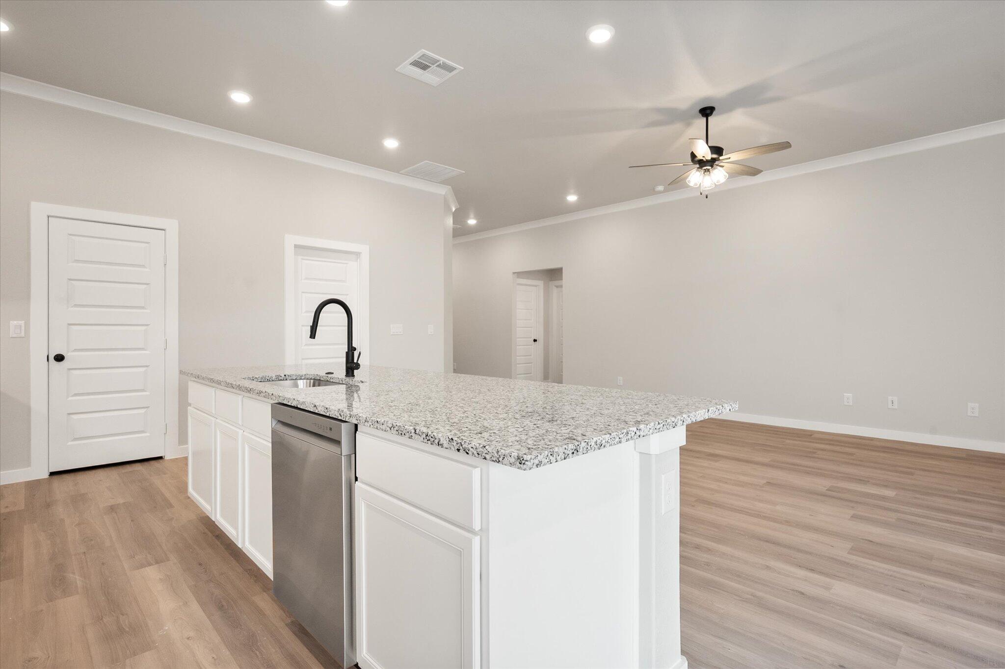 6827 54th Street Lubbock, TX 79407 - Photo 11 of 23 a kitchen with a sink cabinets and wooden floor