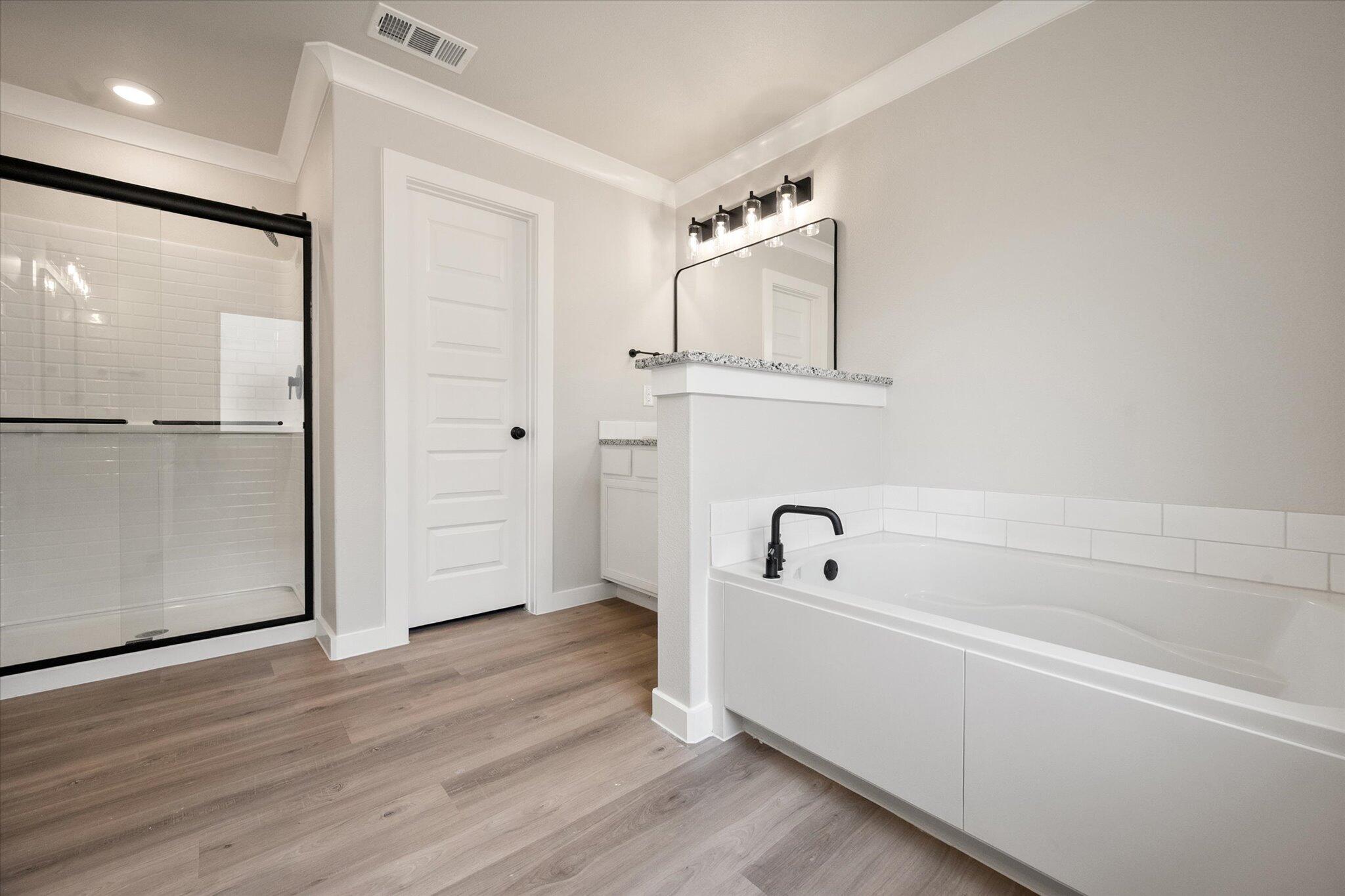6827 54th Street Lubbock, TX 79407 - Photo 15 of 23 a bathroom with a bathtub and a window