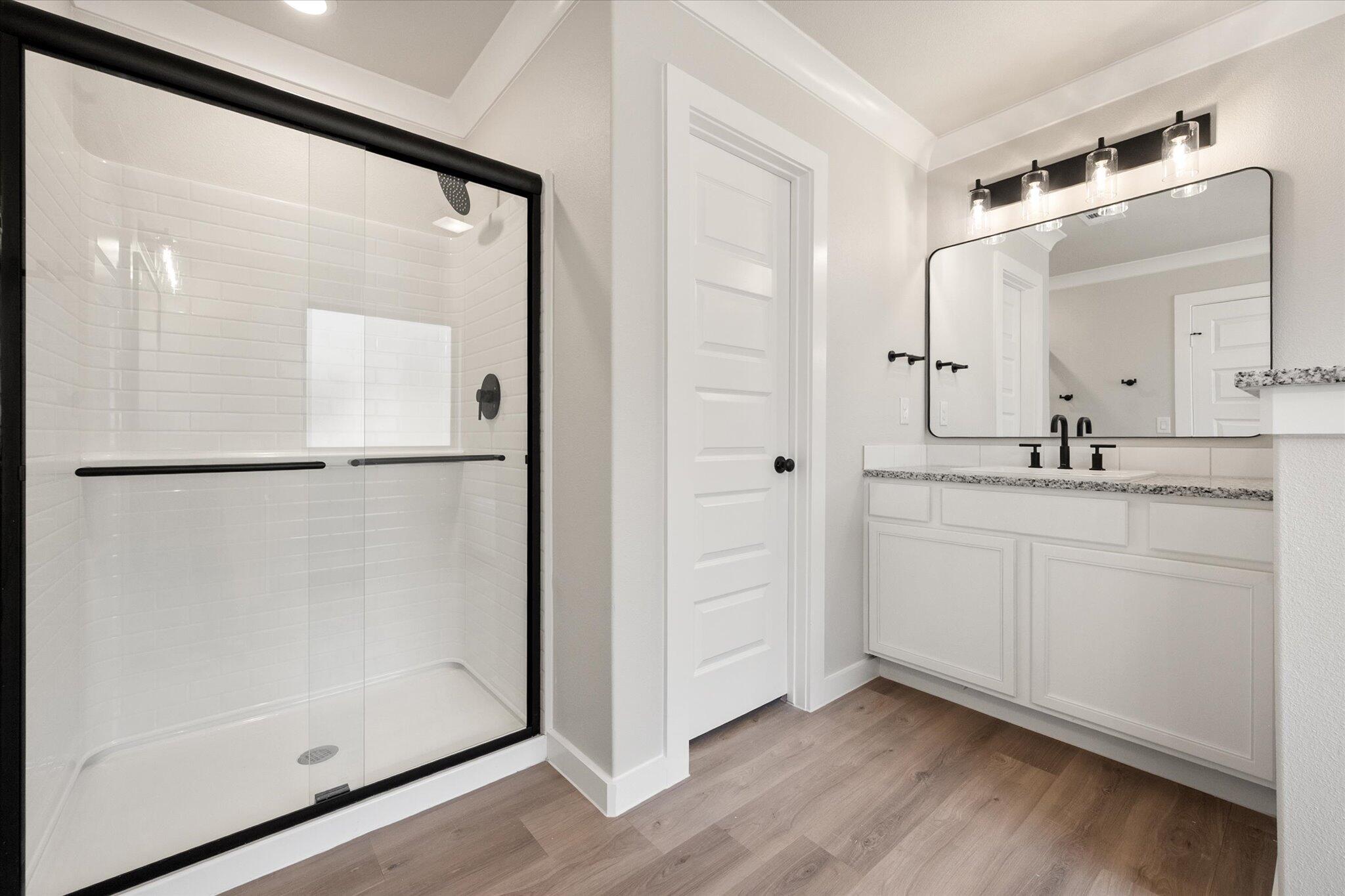 6827 54th Street Lubbock, TX 79407 - Photo 16 of 23 a bathroom with a shower sink and mirror