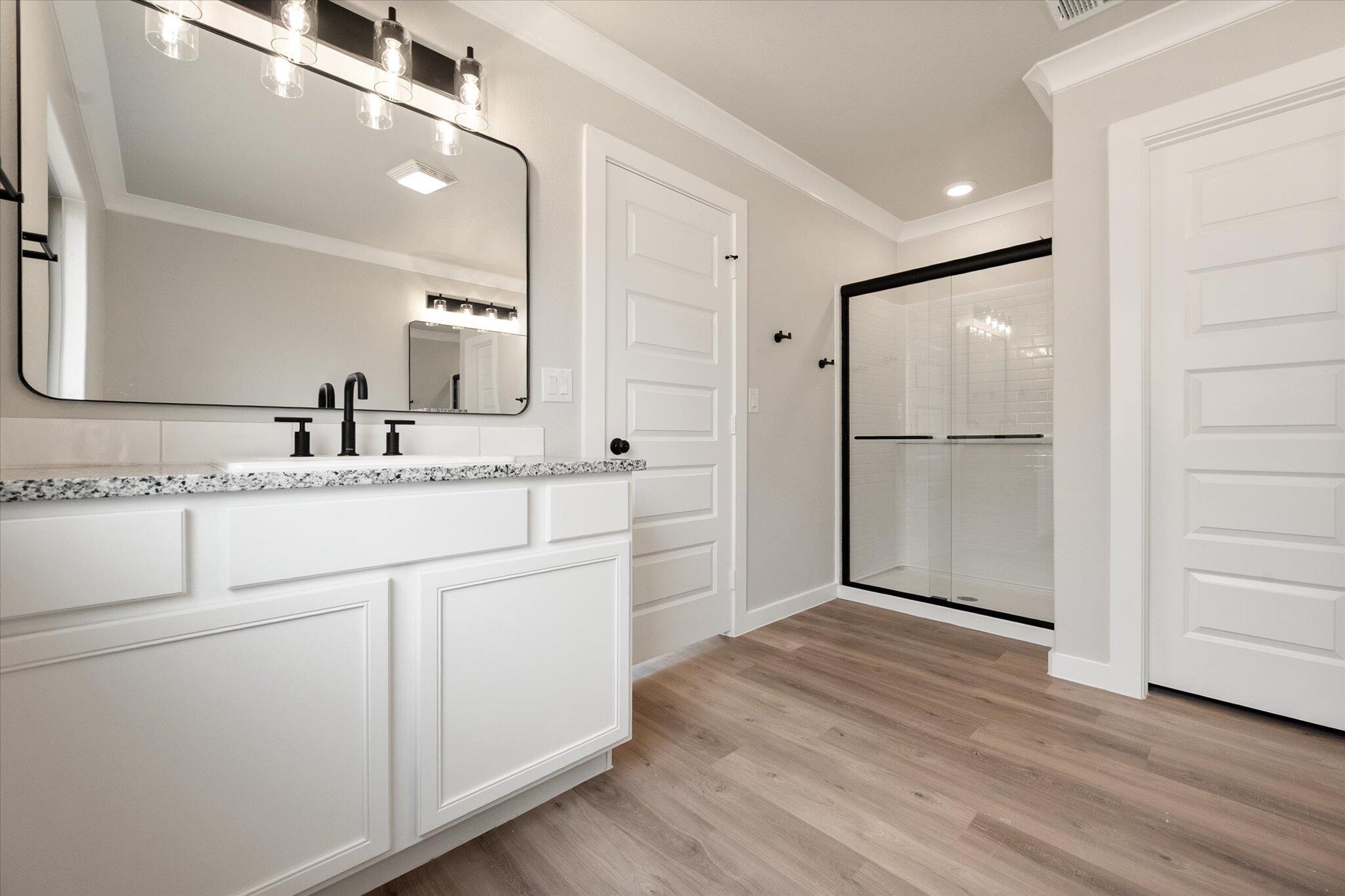 6827 54th Street Lubbock, TX 79407 - Photo 17 of 23 a bathroom with a double vanity sink and mirror