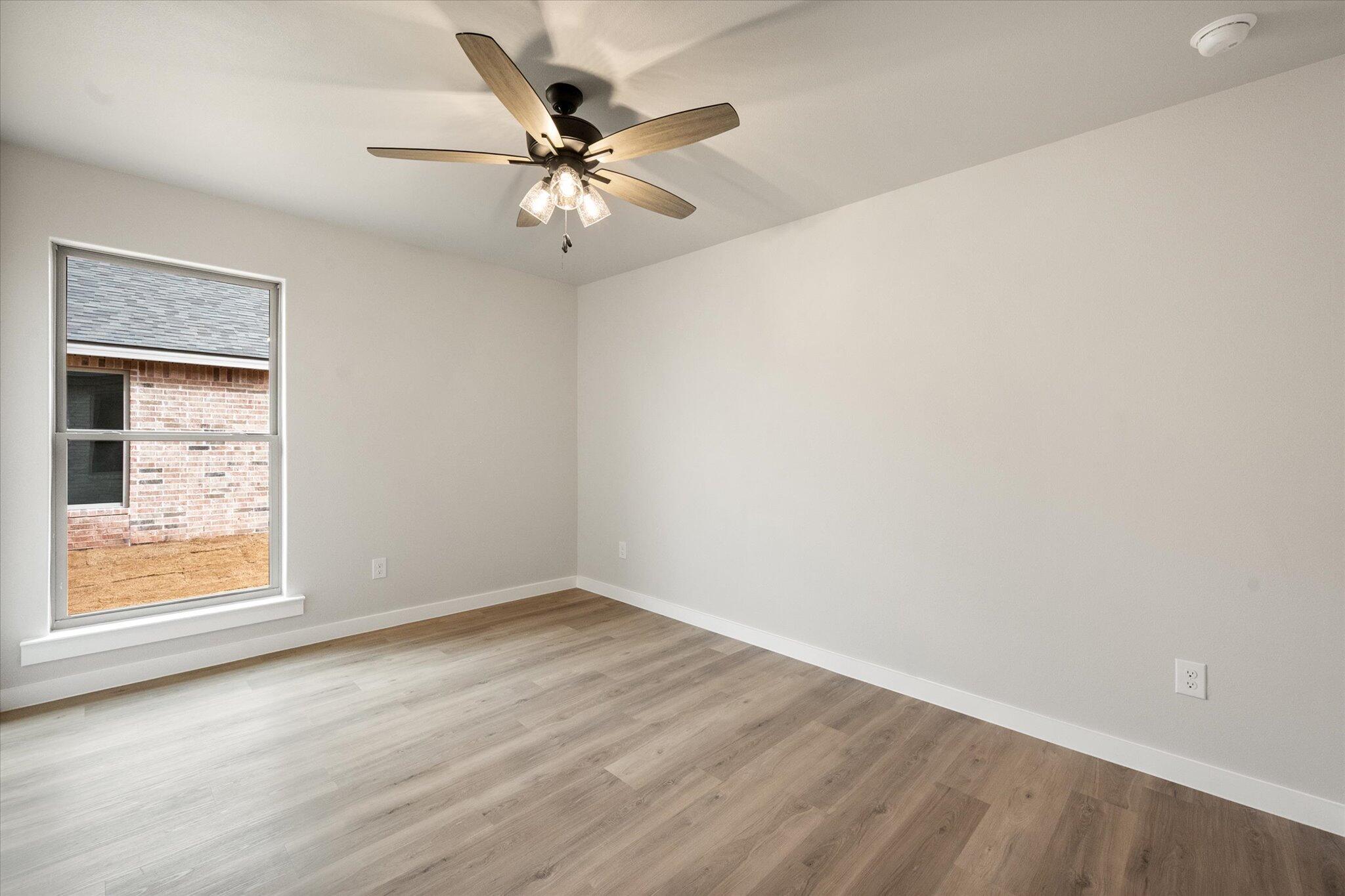 6827 54th Street Lubbock, TX 79407 - Photo 20 of 23 a view of an empty room with wooden floor and a window
