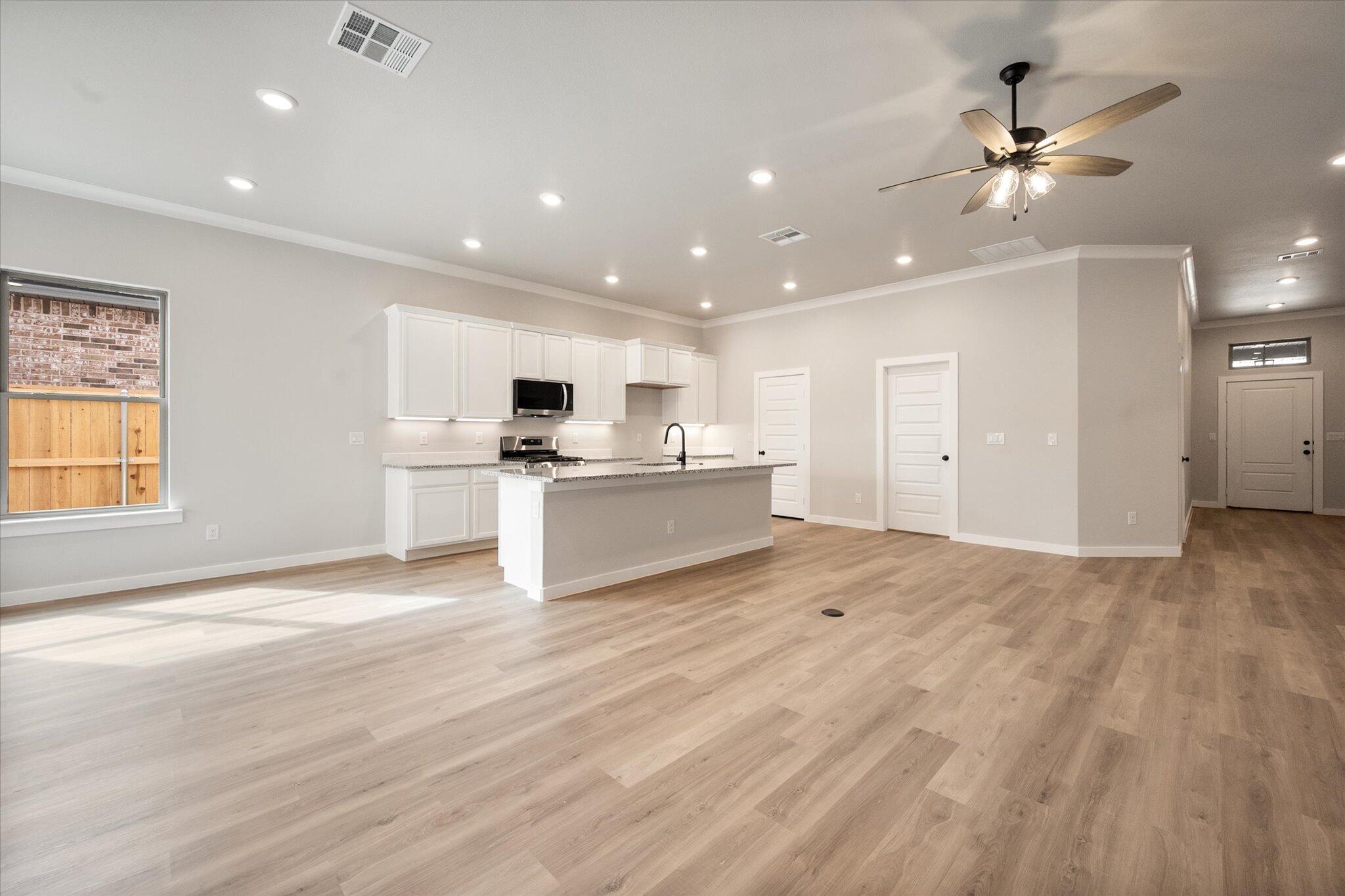 6827 54th Street Lubbock, TX 79407 - Photo 5 of 23 a view of a kitchen with a sink cabinets and wooden floor
