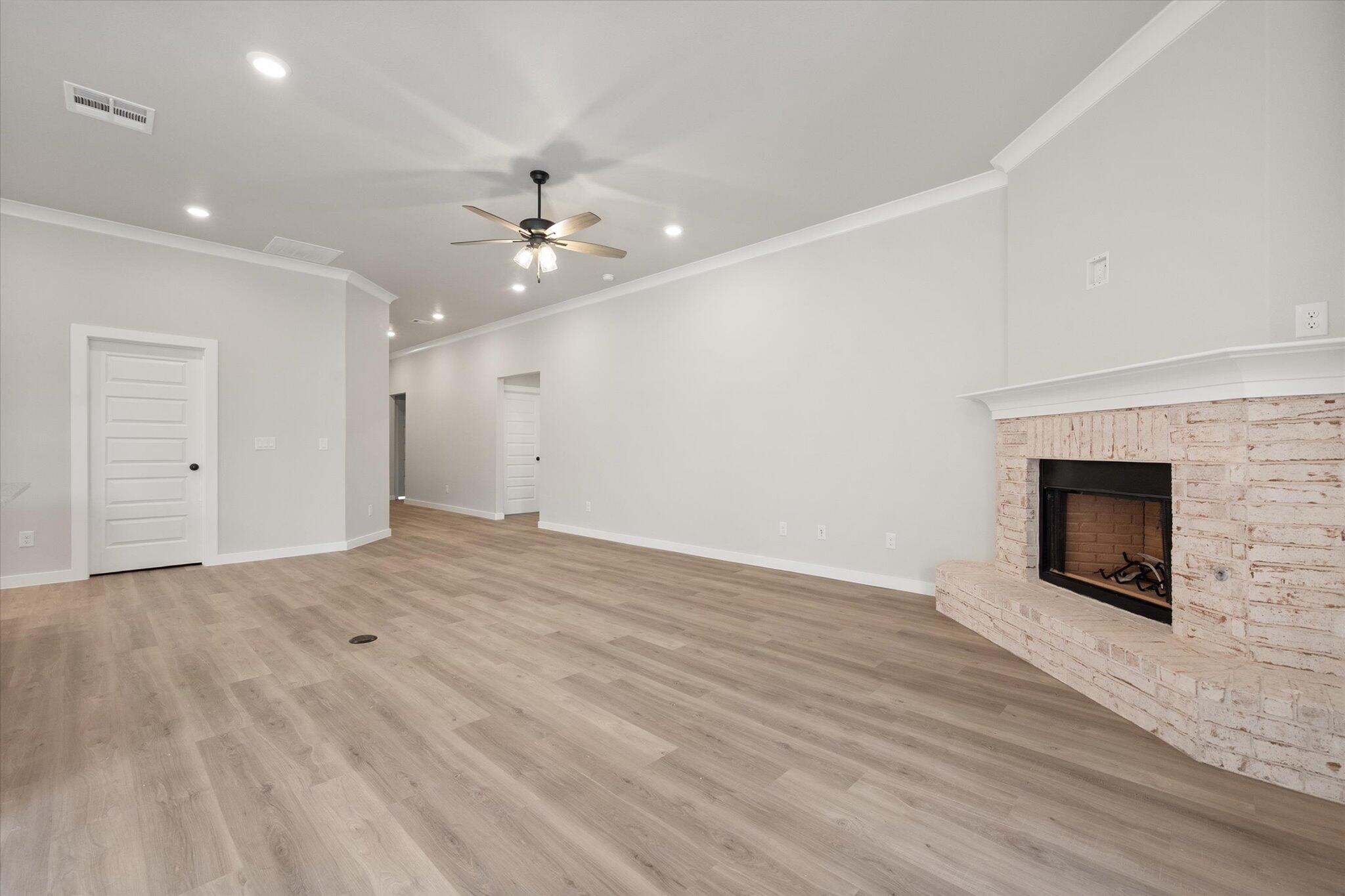 6827 54th Street Lubbock, TX 79407 - Photo 6 of 23 a view of empty room with wooden floor and fireplace