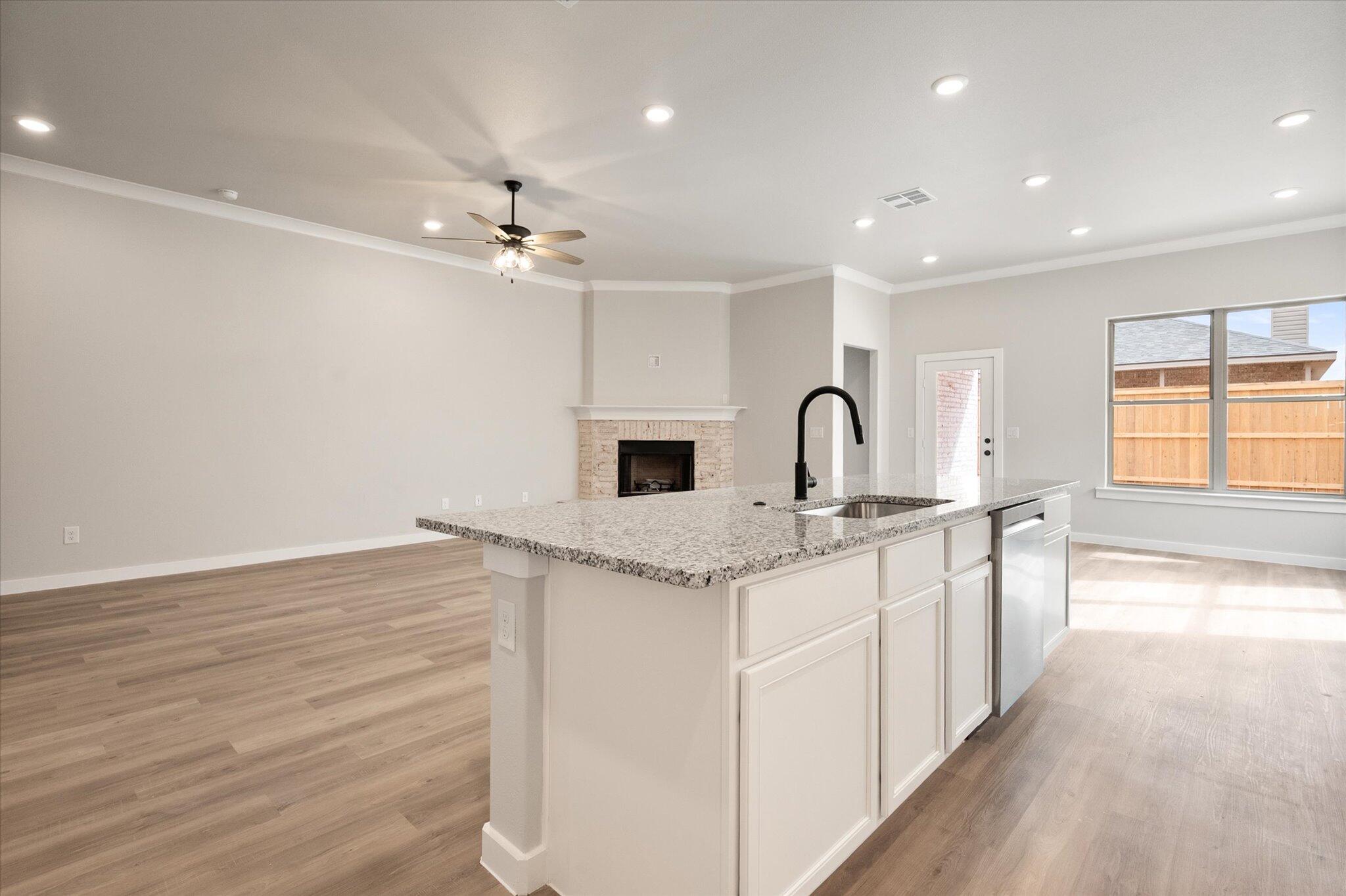 6827 54th Street Lubbock, TX 79407 - Photo 10 of 23 a kitchen with a sink stove and cabinets