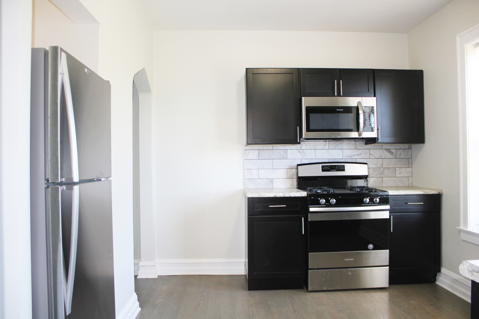 11432 South Indiana Avenue Chicago, IL 60628 - Photo 6 of 21 a kitchen with a stove microwave and refrigerator