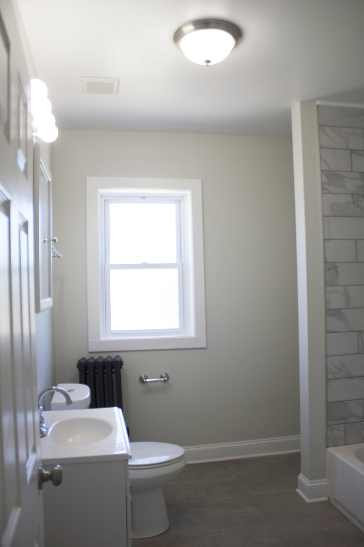 11432 South Indiana Avenue Chicago, IL 60628 - Photo 9 of 21 a bathroom with a sink a toilet and a window