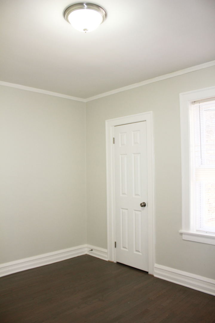 11432 South Indiana Avenue Chicago, IL 60628 - Photo 10 of 21 an empty room with wooden floor and windows