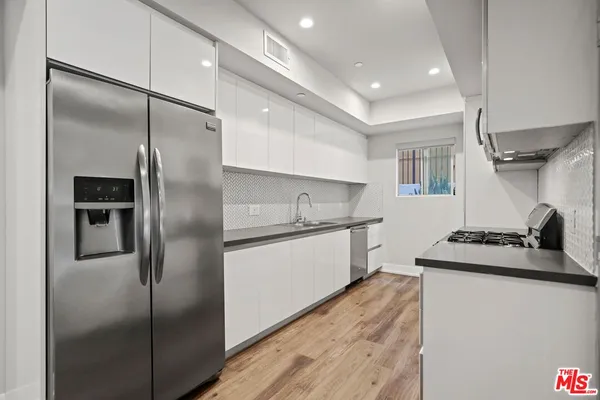 a kitchen with stainless steel appliances kitchen island a refrigerator sink and stove