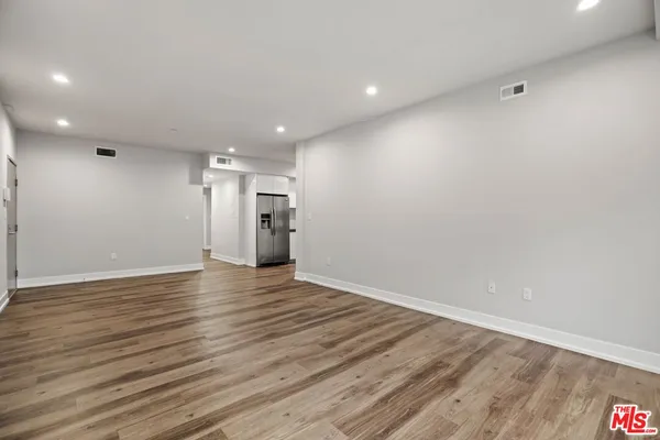 a view of an empty room with wooden floor