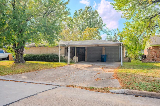 a view of a house with a yard and large tree
