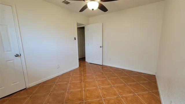 a view of an empty room with a ceiling fan