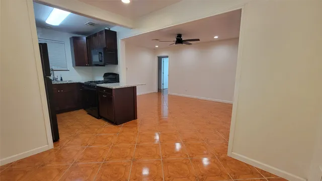 a kitchen with granite countertop a refrigerator and a stove top oven