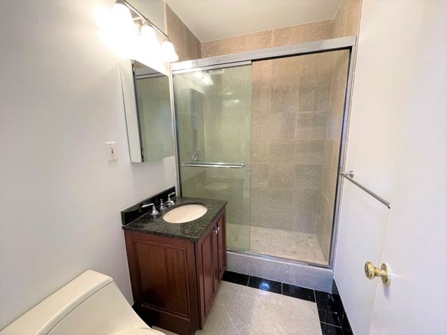 a bathroom with a sink a toilet a mirror and shower