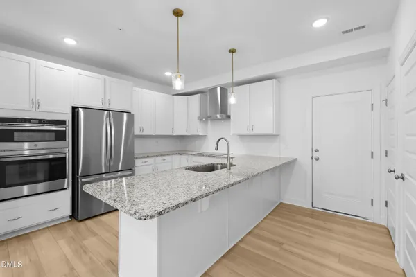 a kitchen with stainless steel appliances granite countertop a sink refrigerator and microwave