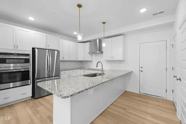 a kitchen with stainless steel appliances granite countertop a sink refrigerator and microwave