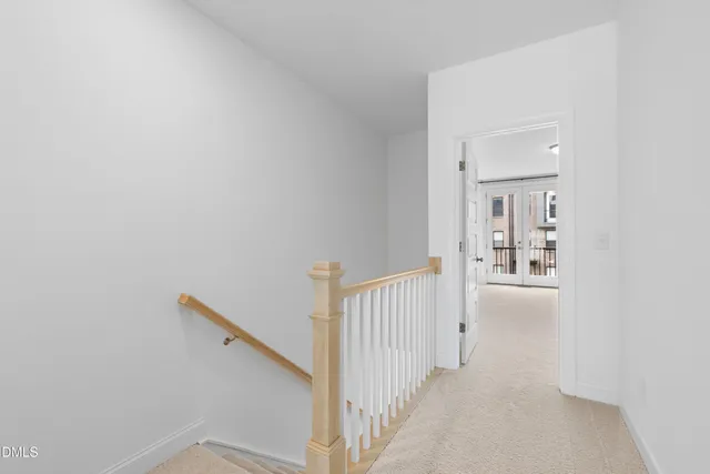 a view of a hallway with a white walls and stairs
