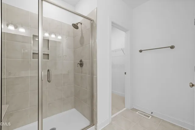 a bathroom with a shower and a glass door