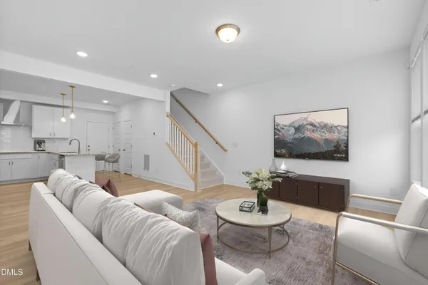 a living room with furniture and a view of kitchen
