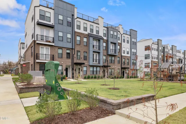 a view of a park with tall buildings