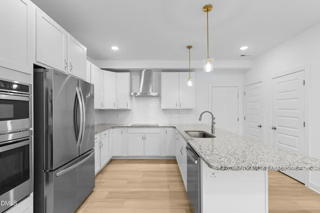 a kitchen with stainless steel appliances granite countertop a sink refrigerator and cabinets