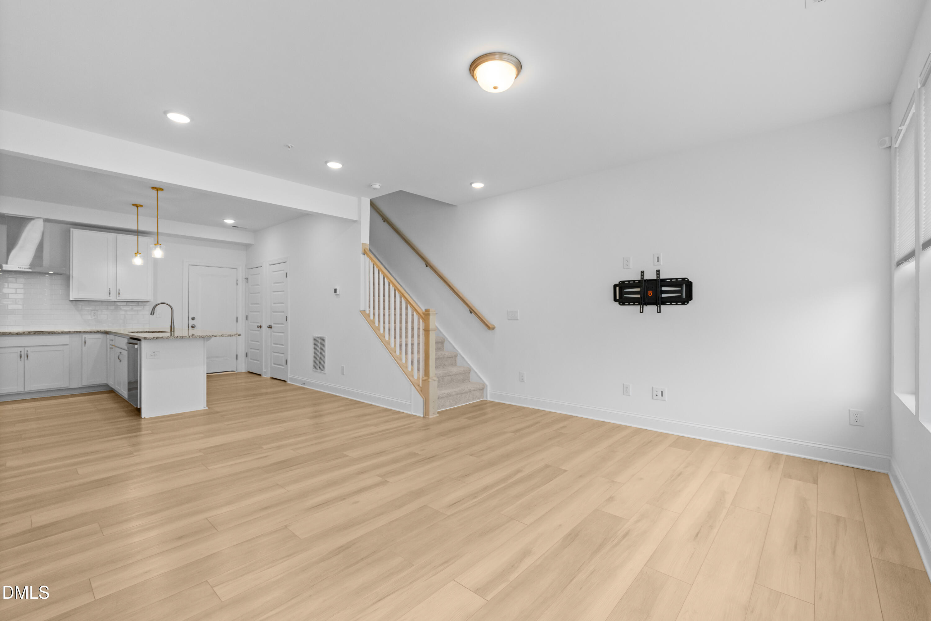 1206 Coach Station Alley Raleigh, NC 27601 - Photo 9 of 38 a view of an empty room with wooden floor and a kitchen