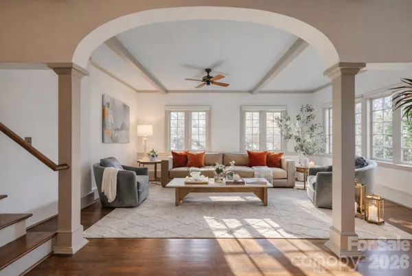 a dining room with furniture potted plants and wooden floor