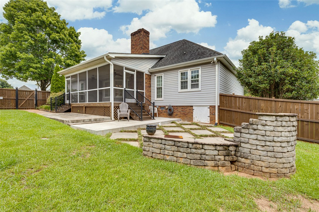 302 Wild Rice Drive Simpsonville, SC 29681 - Photo 40 of 44 Stone pavers and a structured retaining wall define this lush backyard retreat.