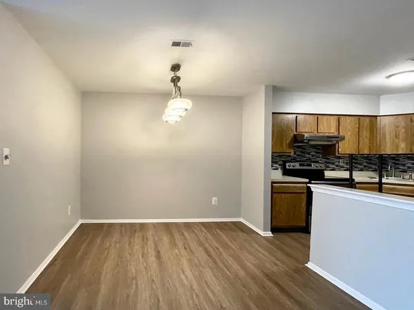 a view of a kitchen with a sink and dishwasher a oven with wooden floor