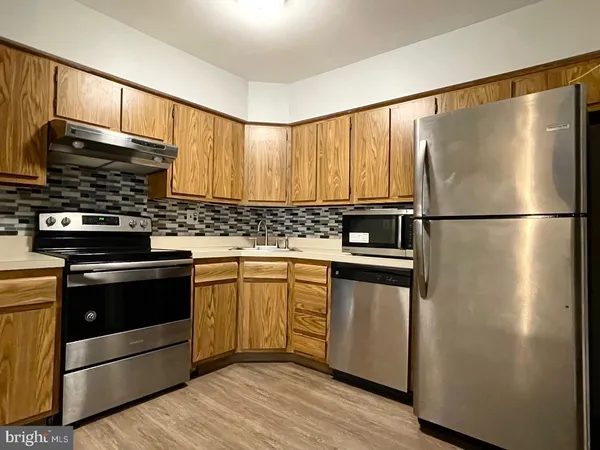 a kitchen with stainless steel appliances a refrigerator sink and cabinets