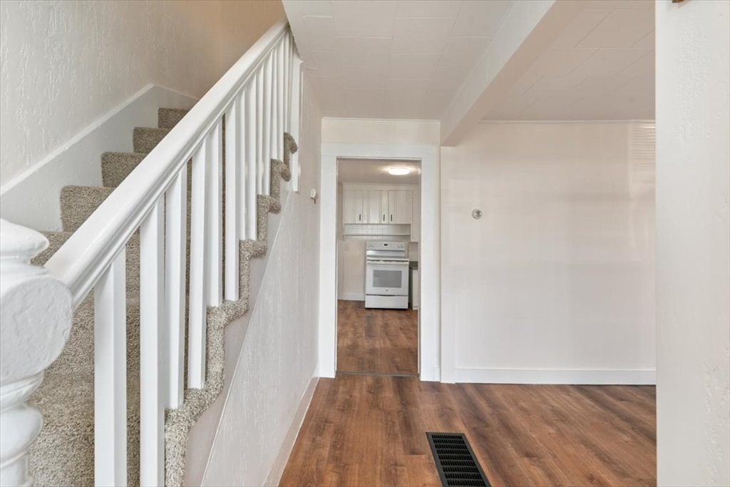 7 Cox Court Beverly, MA 01915 - Photo 2 of 23 a view of a hallway with wooden floor and staircase
